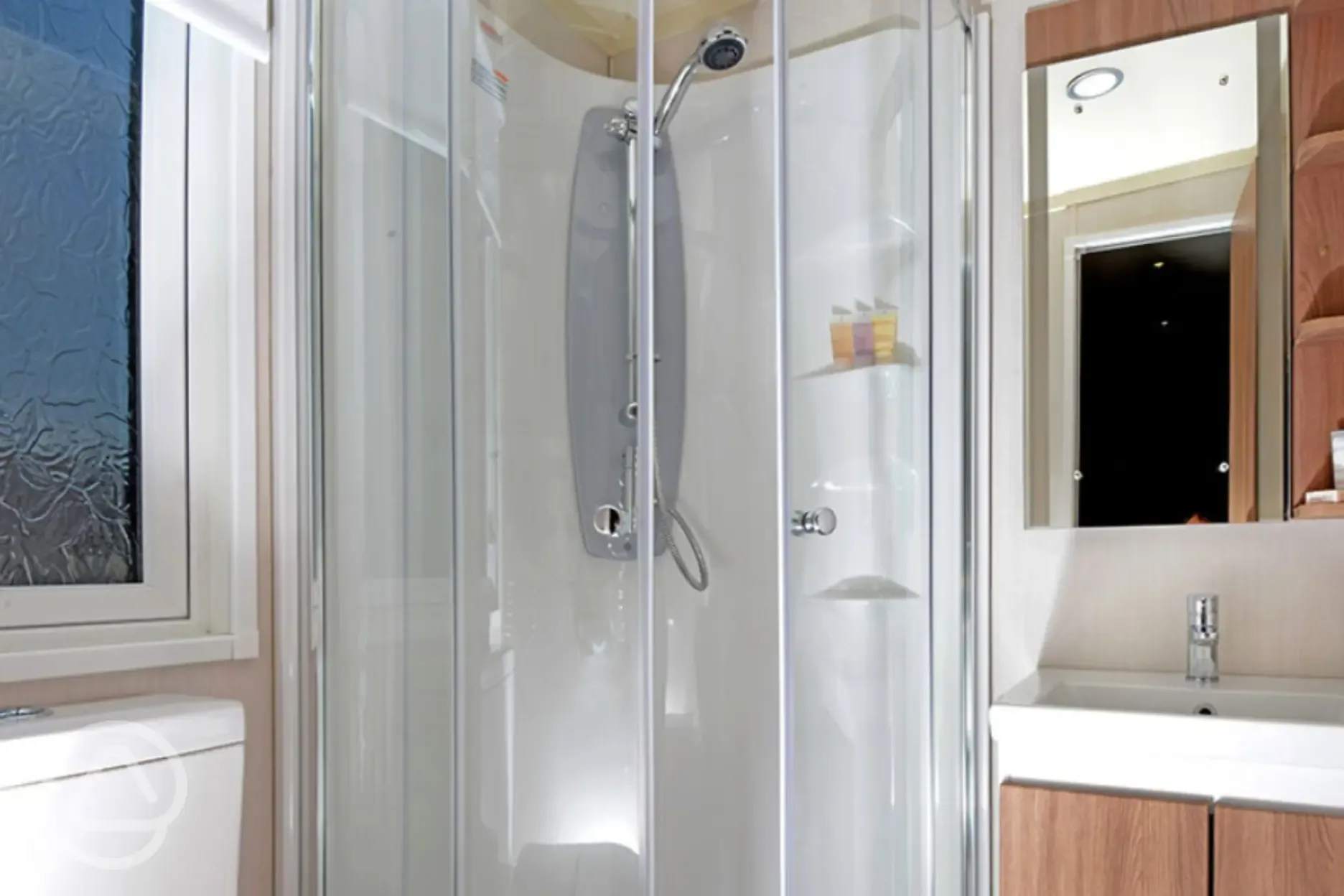 Ensuite room with toilet, shower, and sink in glamiping cabin