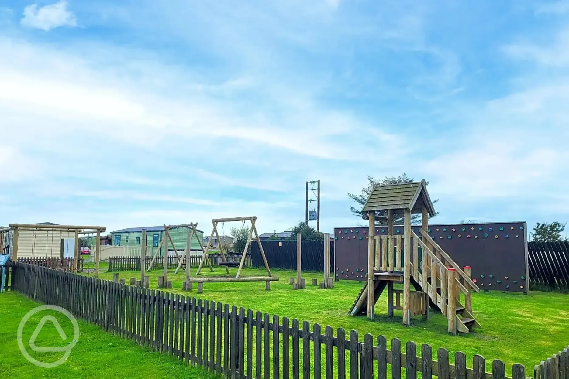 Outdoor childrens play area with swings and a climbing frame