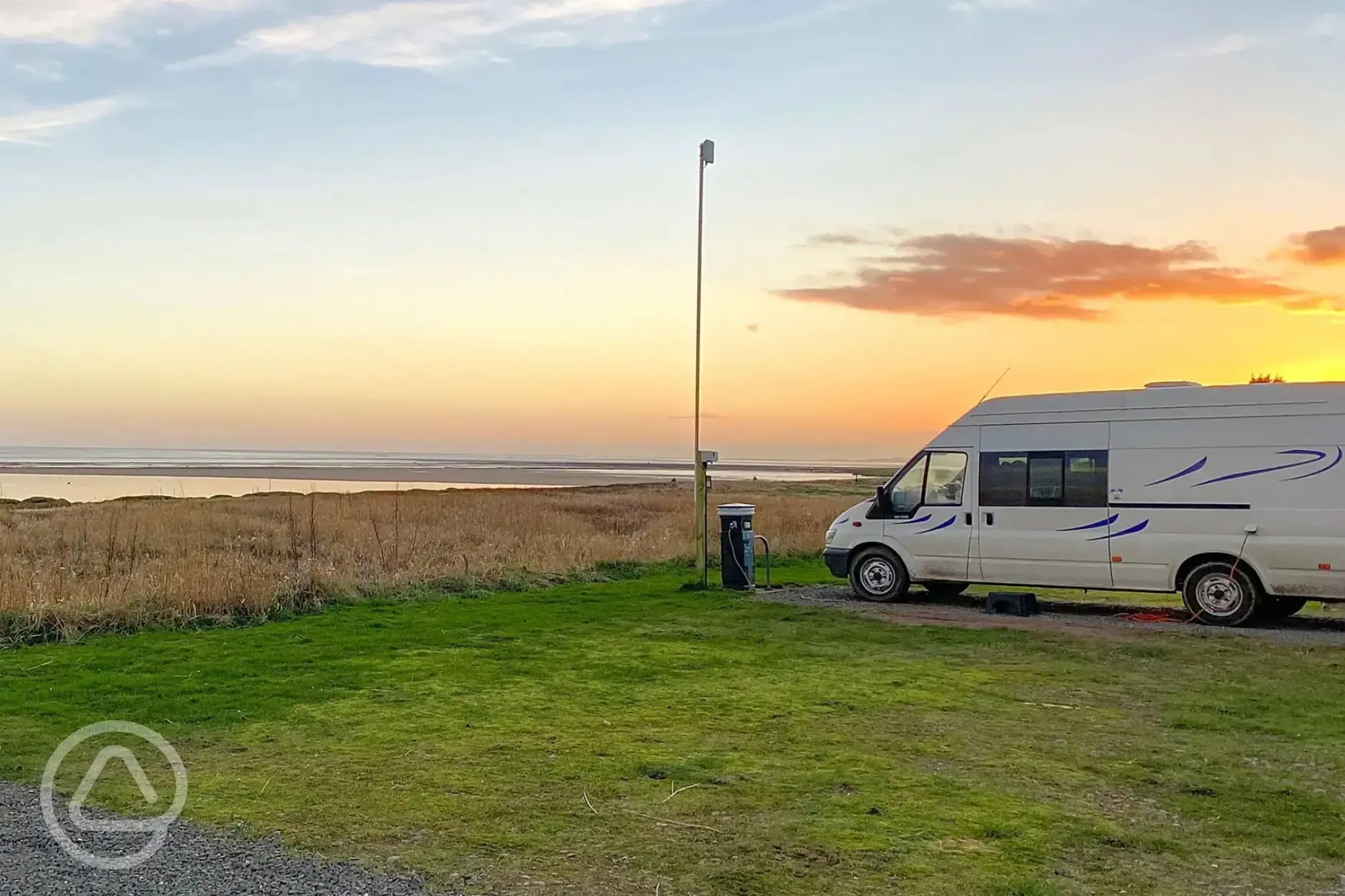 Sandside electric hardstanding touring pitch with sea views at sunset
