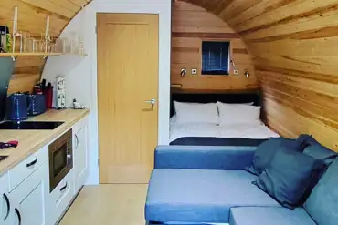 Luxury Cedar Pod interior featuring a double bed and kitchenette at Shays Farm