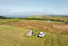 Large tent on a non electric grass pitch with space for a parked car
