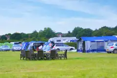 Grass pitches for tents beside outdoor furniture