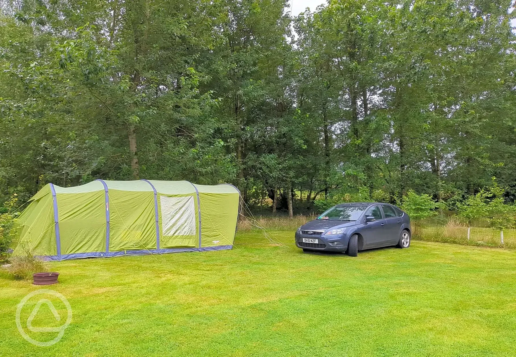 Tent on grass pitch with optional 10 amp hook up and a car parking space