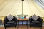 Regular bell tent with a double bed and arm chairs