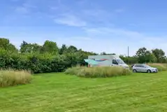 Grass pitches tucked behind long grass banks for added privacy