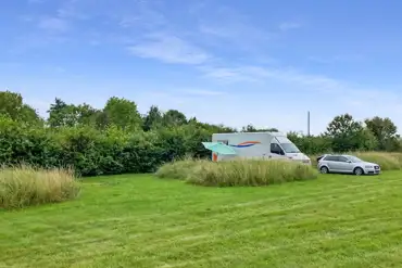 Grass pitches tucked behind long grass banks for added privacy