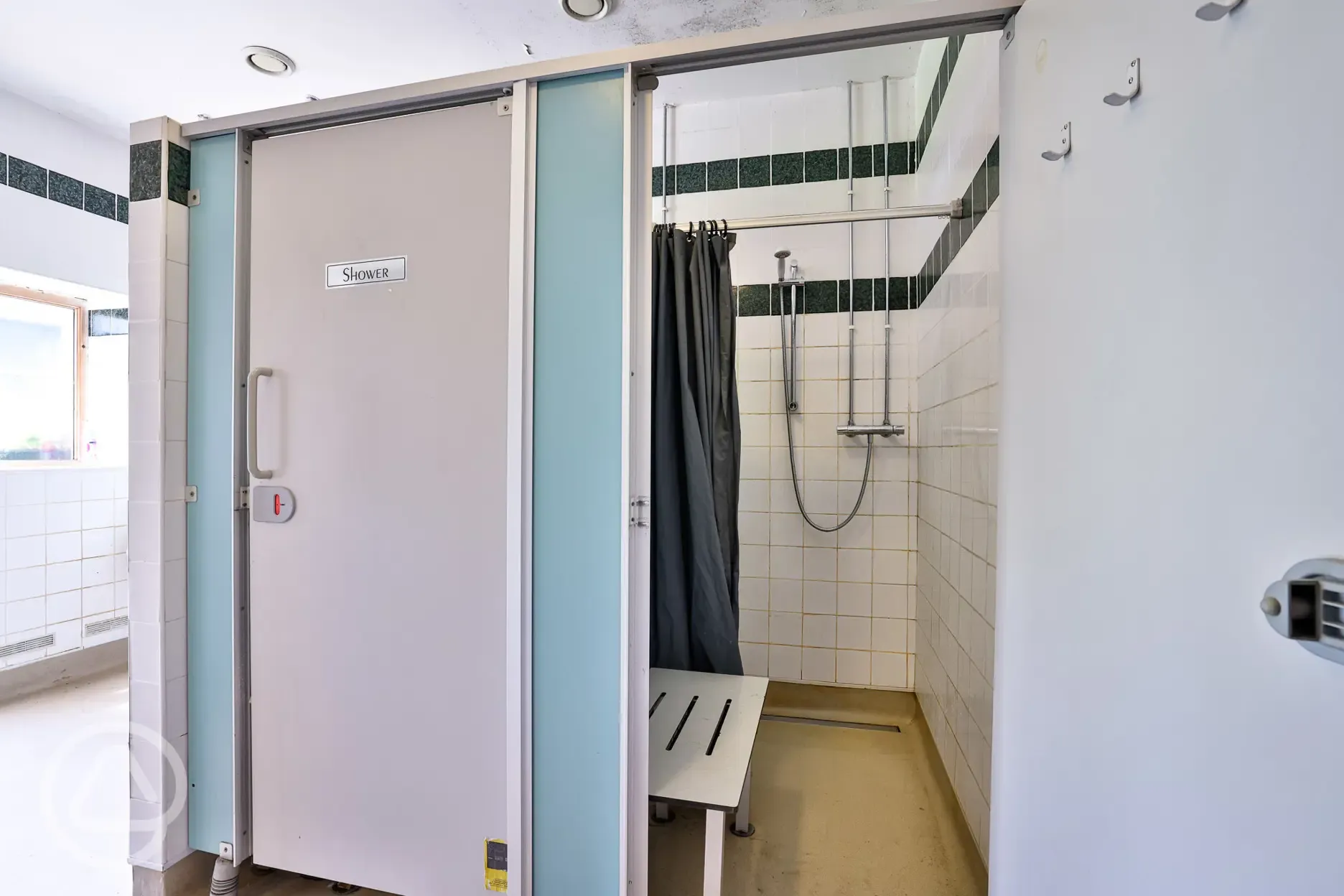 Communal shower cubicles with hot water and a bench
