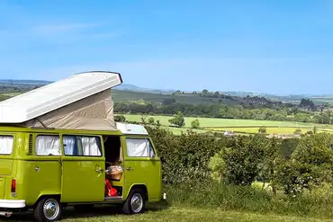 VW campervan on an electric grass pitch at Town Farm Camping