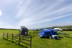 Large tent and VW campervan on a standard non electric pitch in Hemmick Field
