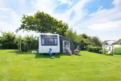 Large grass pitches with 16 amp metered hook ups and hedges on either side