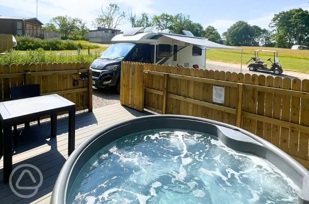 Fully serviced pitches with private hot tubs and a decking/seating area