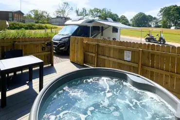 Fully serviced pitches with private hot tubs and a decking/seating area