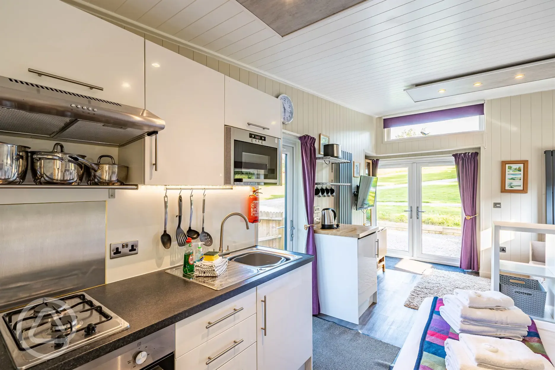 Merlin's Cabin kitchen with a hob, kettle, sink, fridge and microwave