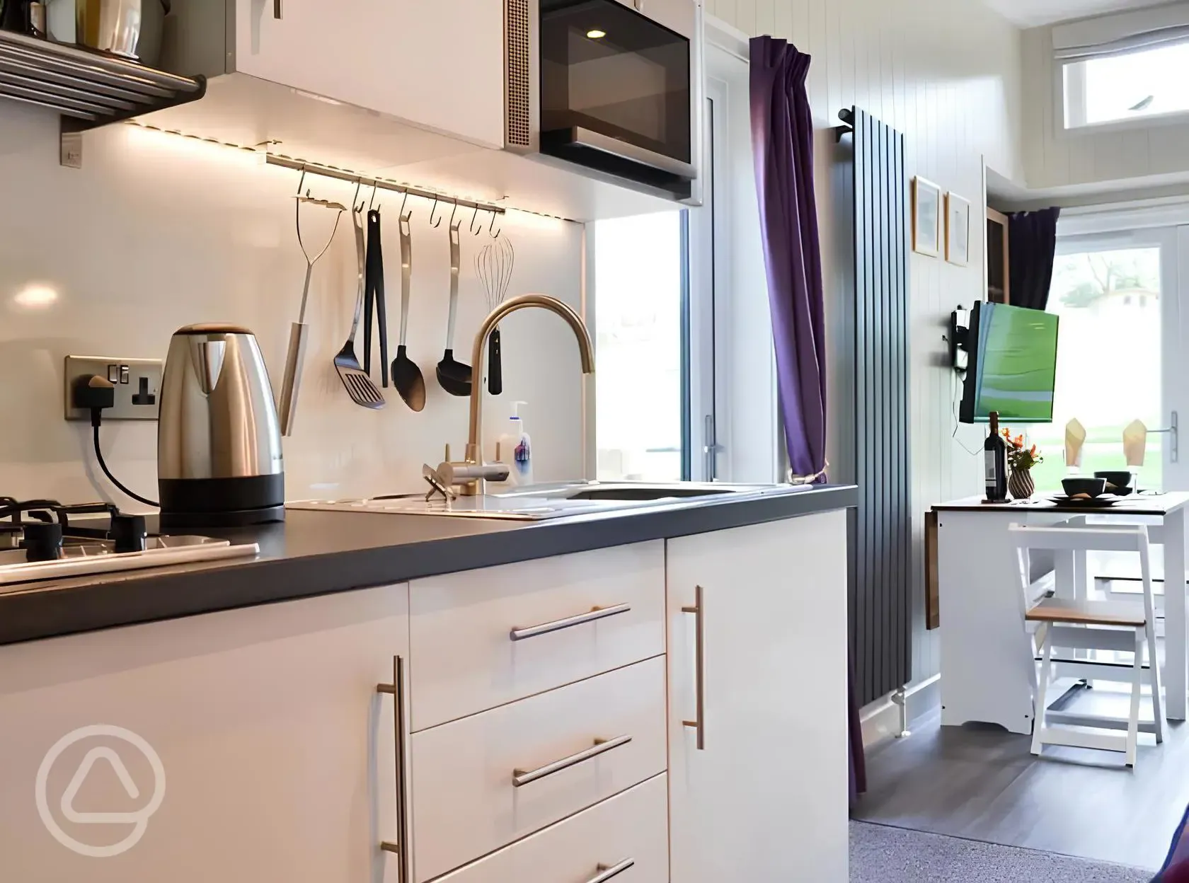 Curlew lodge kitchen with a fridge, kettle, hob, microwave and toaster