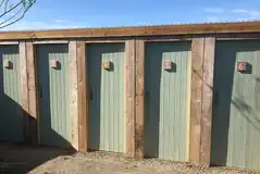 Individual private toilet exterior with numbered doors for each pitch