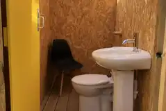 Individual private toilet interior with toilet, mirror and sink
