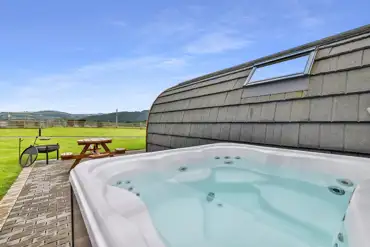 Ensuite glamping pod with a hot tub and a fire pit at Wern Farm Caravan Park