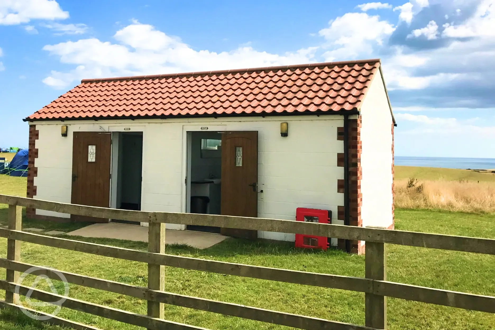Facilities block with male and female toilets, plus a covered washing up area