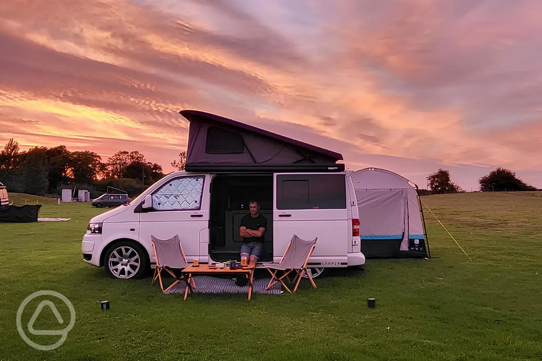 Small campervan on grass pitches during sunset at Field Farm Fisheries Small campervan on grass pitches during sunset at Field Farm Fisheries