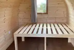 Camping pod interior with a double bed frame 
