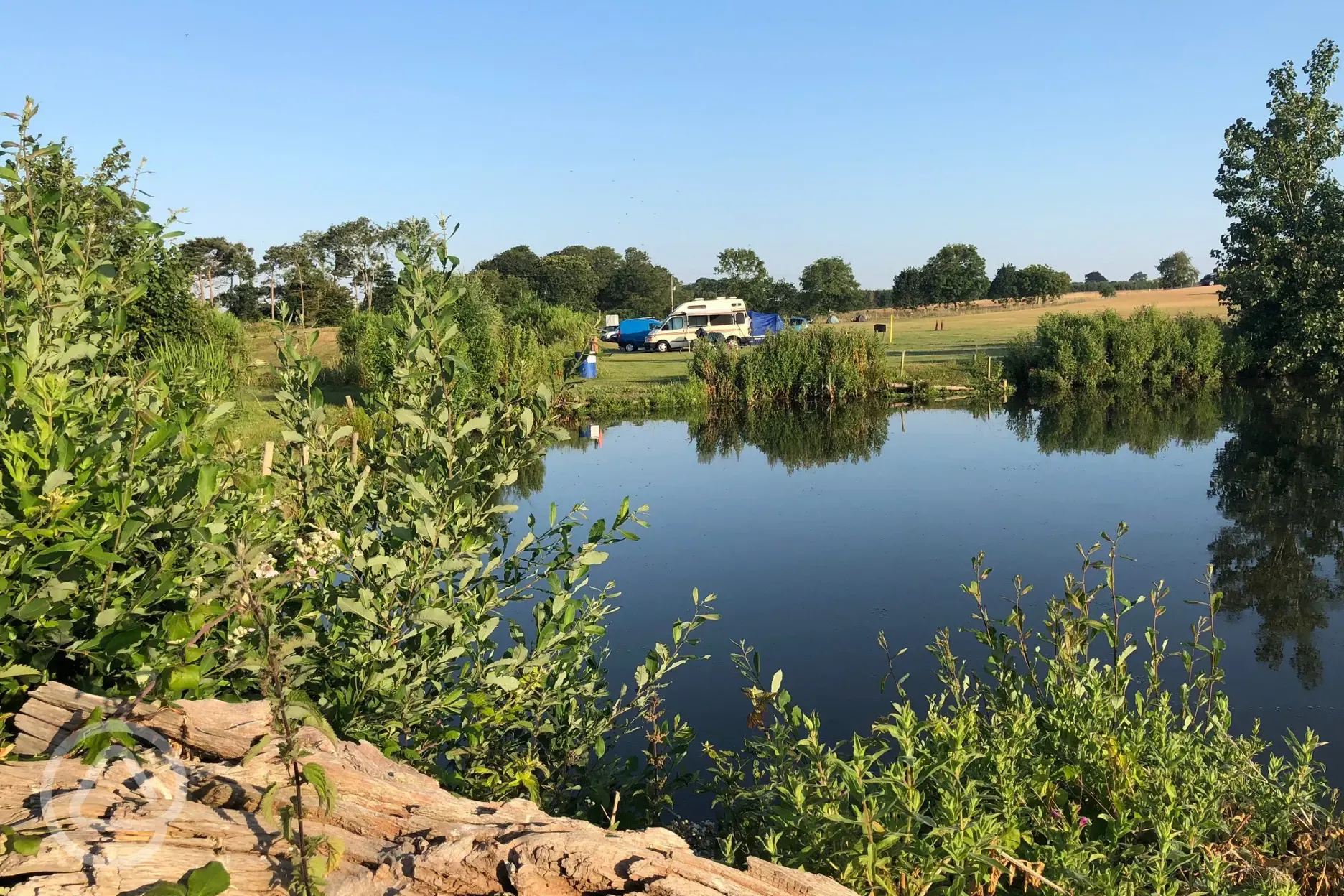 Grass pitches by the Field Farm Fisheries' fishing lake Grass pitches by the Field Farm Fisheries' fishing lake