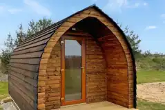 Camping pod exterior with private fire pit and picnic bench 