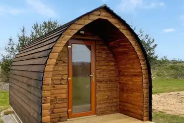 Camping pod exterior with private fire pit and picnic bench 
