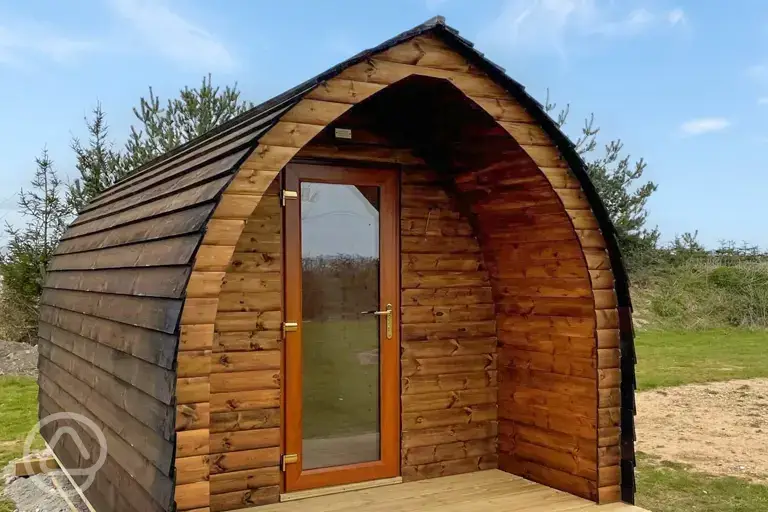 Camping pod exterior with private fire pit and picnic bench 