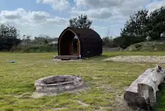 Camping pod with large fire pit and wooden bench