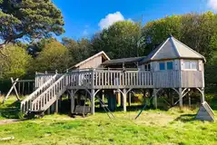 Harvest Moon Holidays treehouse with a large deck, swings and beach access