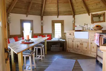 Treehouse living area and kitchen with a log burner, hobs and Belfast sink