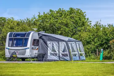 Caravan with awning on a fully serviced hardstanding pitch at Hungerford Farm