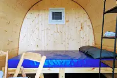 Green camping pod interior with a double bed (bring own bedding or hire)