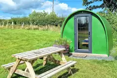 Green camping pod with a private picnic bench