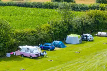 Aerial of the non electric grass pitch with sunken fire pits