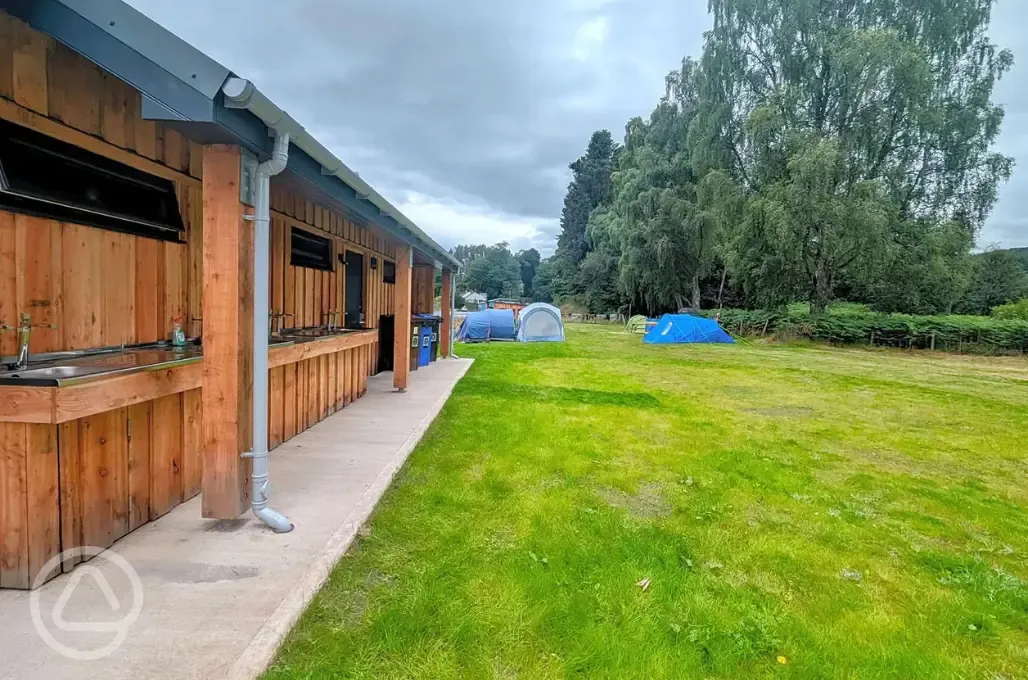 Facility block with an outdoor washing up area beside the pitches