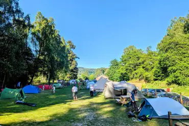 Tents on grass pitches next to a car park at Grandtully Station Campsite
