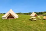 Unfurnished bell tents with outdoor seating