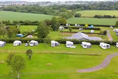 Aerial of the grass touring pitches backed by a hedgerow