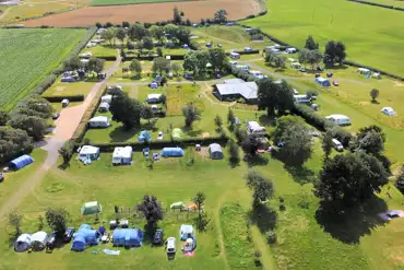 Campsite aerial with hedges and trees between areas of the site