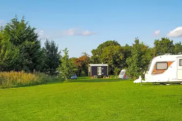 Shepherds hut and grass pitches at Rectory Farm Caravan Camping and Fishing Site