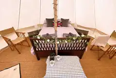 Goldfinch bell tent featuring a king size bed, wood burning stove, and furniture Goldfinch bell tent featuring a king size bed, wood burning stove, and furniture