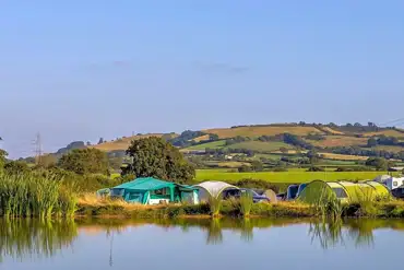 Camping field by the fishing pond at The Dorset Hideaway