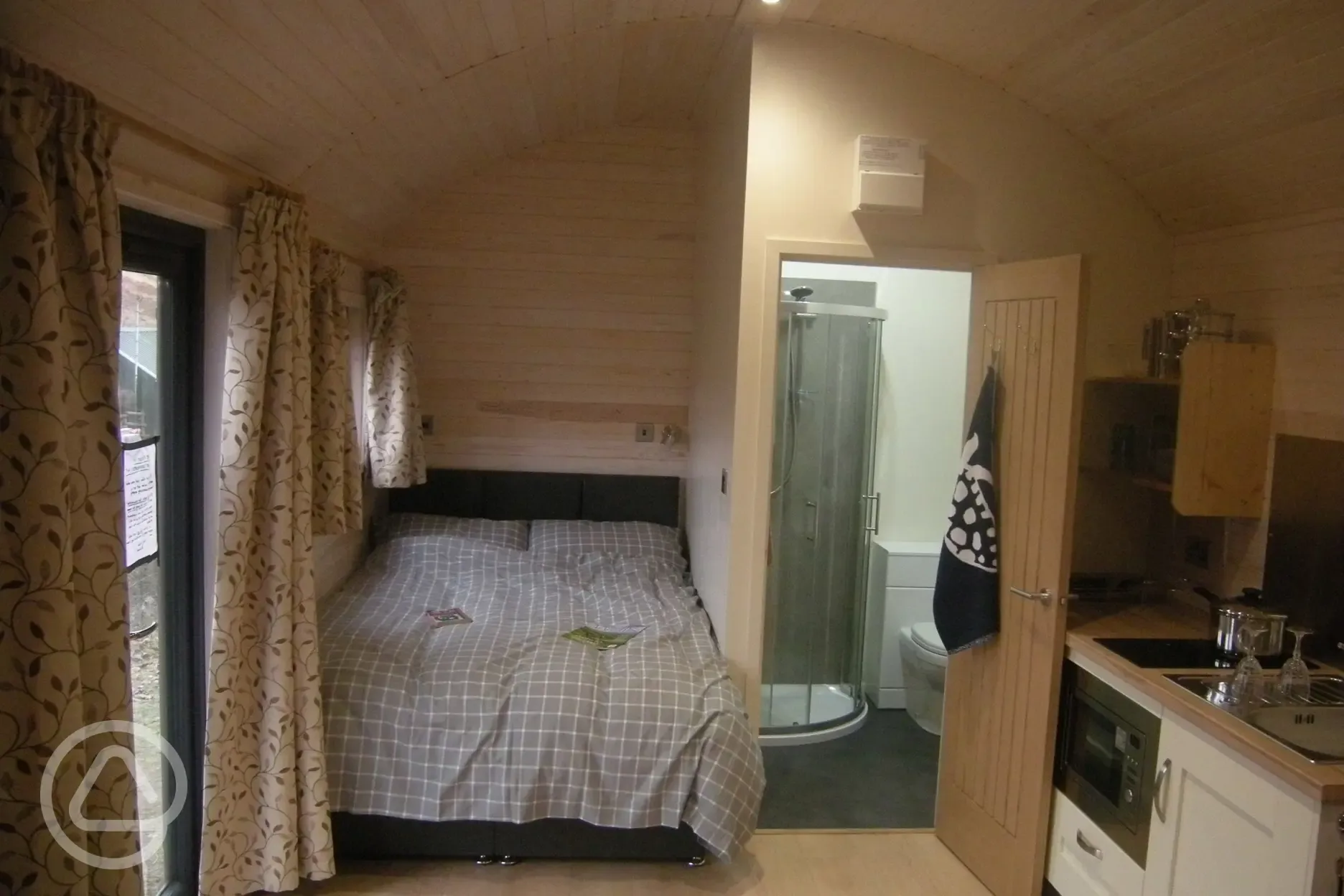 Double bed, shower room and cooking area of shepherd's hut