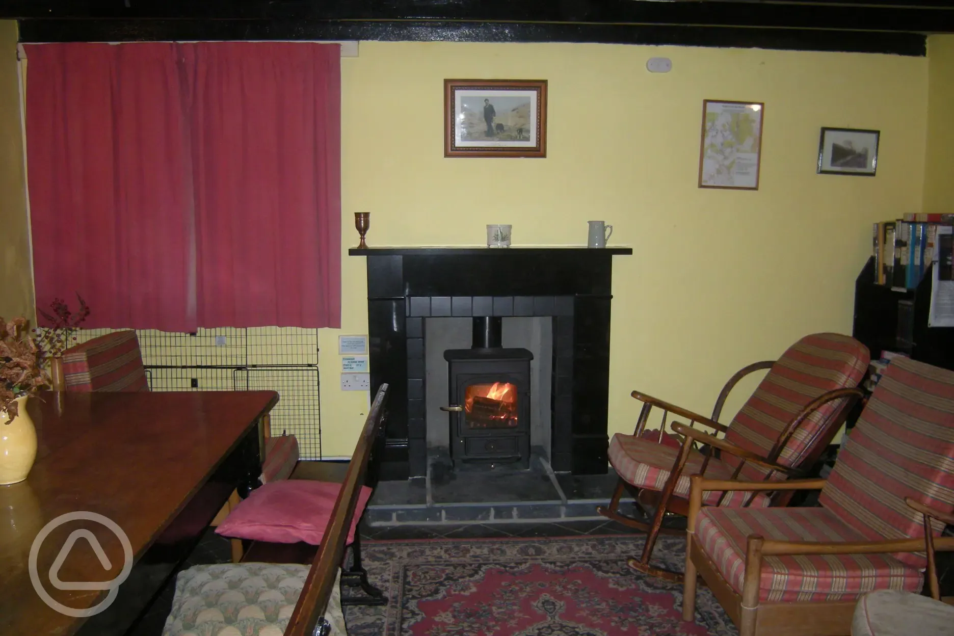 Common room of Tyncornel hostel with wood burning stove 