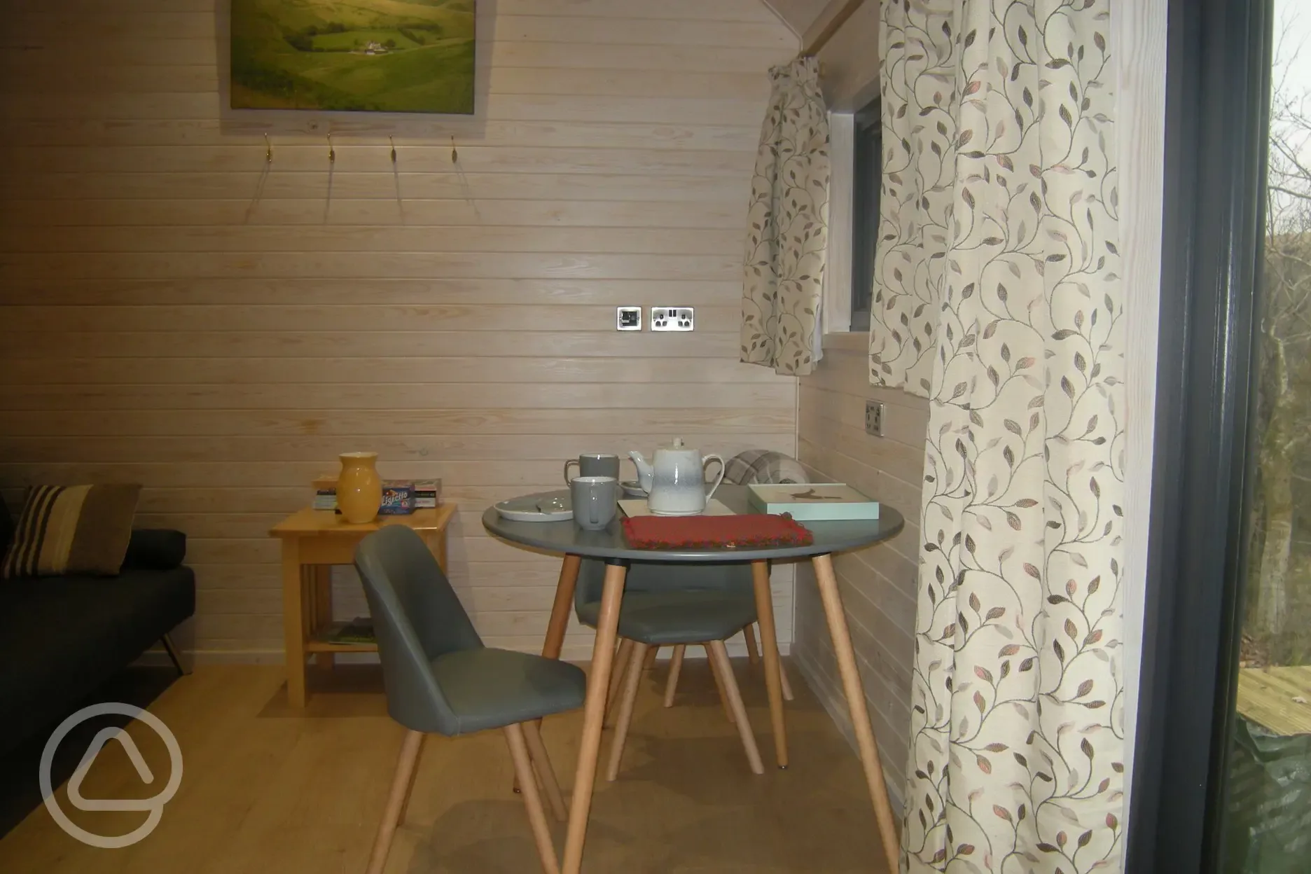 Inside shepherd's hut, seating area with bed settee on left