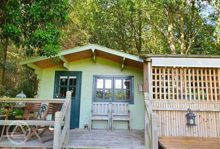 Cherry Tree glamping cabin with an outdoor deck and furniture
