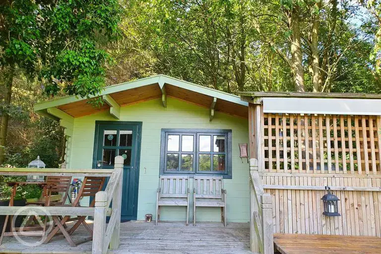 Cherry Tree glamping cabin with an outdoor deck and furniture