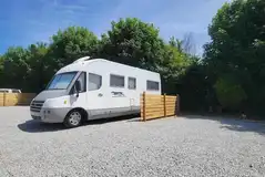 Fenced electric hardstanding pitches with a grass area