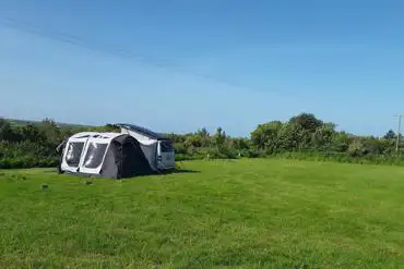 Large grassy pitch at Higher Cheristow Farm Campsite 